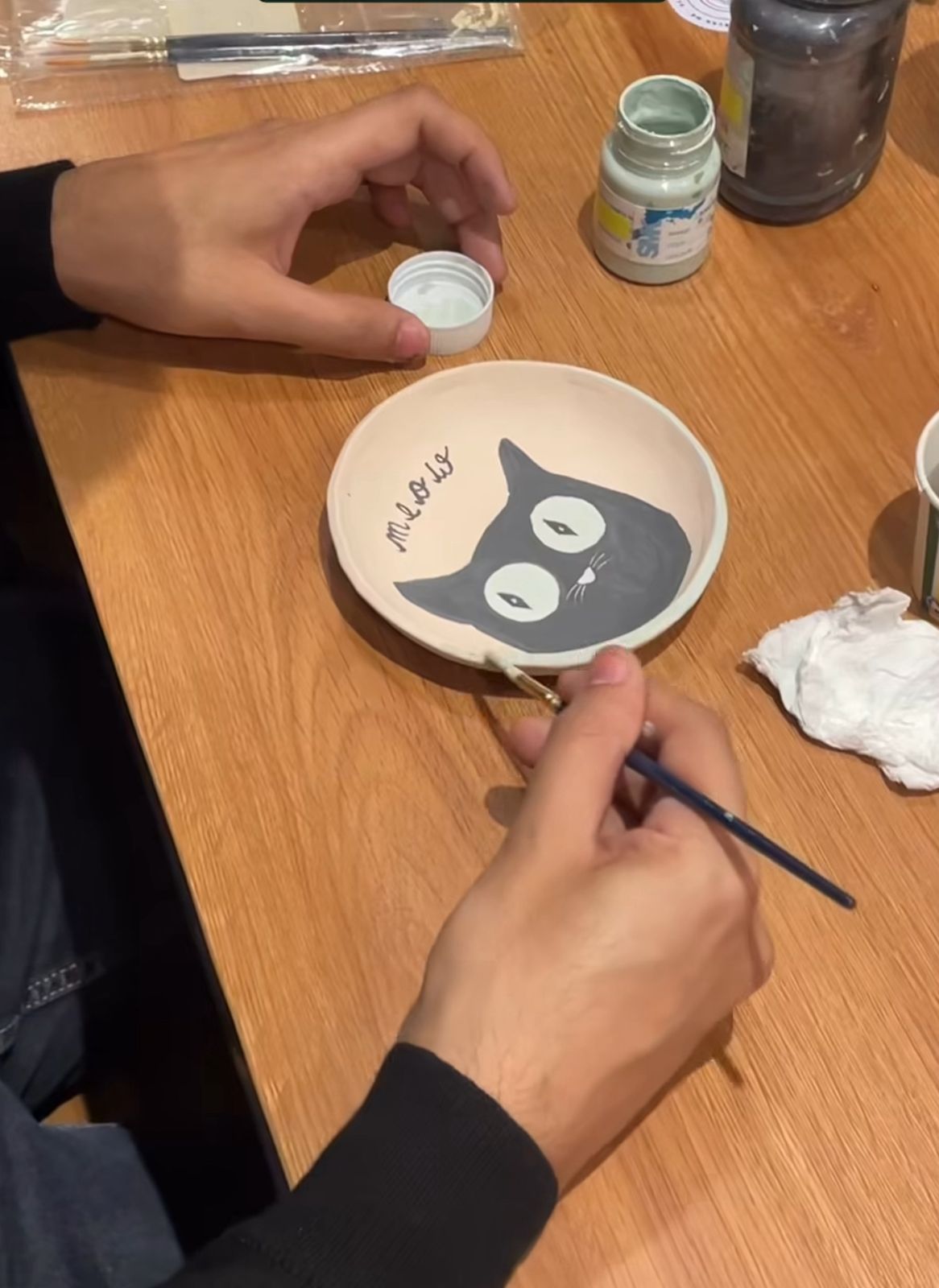 Guests painting ceramic pieces together at Green Neko