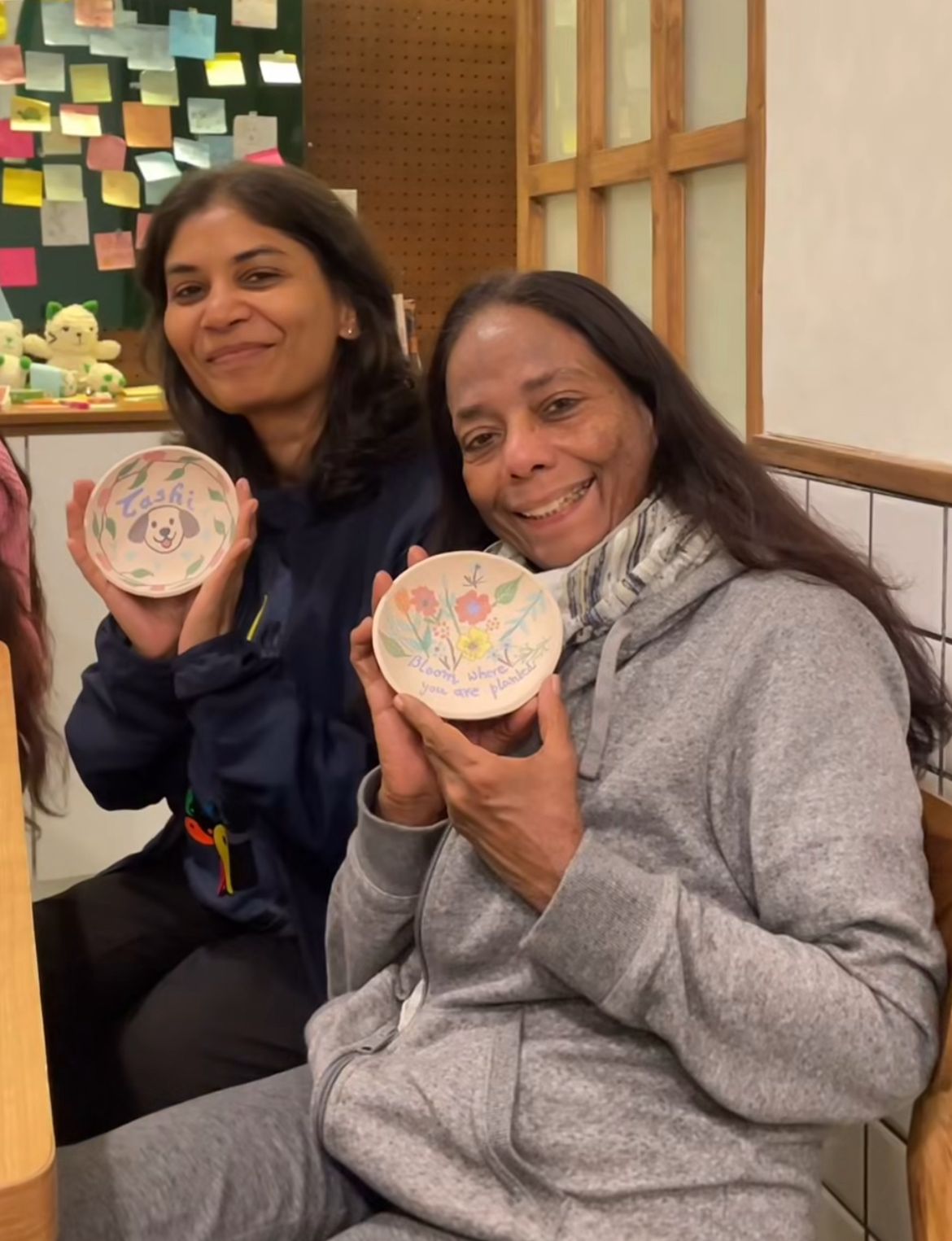 Two guests showing their hand-painted ceramic pieces